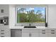 The kitchen sink has a scenic backyard view with stainless steel appliances and white cabinetry at 20307 74Th E Ave, Bradenton, FL 34202
