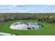 Overhead image of an on-property pond with a dock surrounded by tall green trees at 20307 74Th E Ave, Bradenton, FL 34202