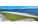 Expansive backyard with lush green grass, a sandy beach area, and a picturesque view of the lake at 227 Maraviya Blvd, Nokomis, FL 34275