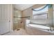 Bright bathroom with glass shower, soaking tub, and decorative window treatment at 227 Maraviya Blvd, Nokomis, FL 34275