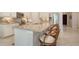Granite kitchen island with bar stool seating, stainless steel appliances, and cream colored cabinets at 227 Maraviya Blvd, Nokomis, FL 34275