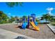 Community playground featuring slides, climbing structures, and a soft landing surface with lake and building view at 227 Maraviya Blvd, Nokomis, FL 34275