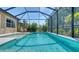 Sparkling screened-in pool with shallow entry, surrounded by lush landscaping and lounge chairs at 227 Maraviya Blvd, Nokomis, FL 34275