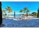 Resort-style pool area with palm trees, a fire pit, and comfortable lounge chairs at 227 Maraviya Blvd, Nokomis, FL 34275