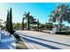 Inviting street view of lush landscaping and palms surrounding a community entrance under a clear blue sky at 227 Maraviya Blvd, Nokomis, FL 34275
