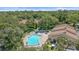 Aerial view of community pool with lounge chairs surrounded by mature landscaping at 2640 Clubhouse Dr # 204, Sarasota, FL 34232