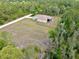 Aerial view of the property showcasing the home, the expansive yard and lush surroundings at 27207 Treadmill Dr, Punta Gorda, FL 33955