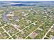 Aerial view of a neighborhood showing houses interspersed with trees and bisected with long straight roads at 27207 Treadmill Dr, Punta Gorda, FL 33955
