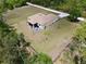 Aerial view of fenced backyard featuring a patio with outdoor seating and lush green landscaping at 27207 Treadmill Dr, Punta Gorda, FL 33955