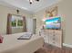 Comfortable bedroom featuring a wooden floor, dresser, and natural light from the window at 27207 Treadmill Dr, Punta Gorda, FL 33955