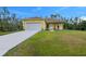 Charming yellow single-story home with a well-maintained lawn and a long driveway leading to an attached two-car garage at 27207 Treadmill Dr, Punta Gorda, FL 33955