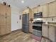 Kitchen features stainless steel appliances, wood cabinets, and durable wood-look floors, creating a warm and inviting space at 27207 Treadmill Dr, Punta Gorda, FL 33955