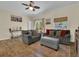 Comfortable living room with hardwood floors, two sofas, neutral tones, and natural light from the windows at 27207 Treadmill Dr, Punta Gorda, FL 33955