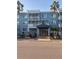 Inviting building entrance with covered walkway, lush landscaping, and swaying palm trees offering shade at 2755 Coconut Bay Ln # 1313 3M, Sarasota, FL 34237