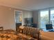 Sun-drenched living room with dining area, sliding glass doors, and balcony, showcasing modern living at 2755 Coconut Bay Ln # 1313 3M, Sarasota, FL 34237