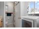 Bathroom featuring tiled shower, laundry machine, toilet, and storage at 3041 Teal Ave, Sarasota, FL 34232