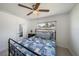 Charming bedroom with a ceiling fan, large window, and a comfortable bed with a blue and white patterned quilt at 3041 Teal Ave, Sarasota, FL 34232