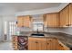 A kitchen with wood cabinets, granite countertops, a black sink, and stainless steel appliances at 3041 Teal Ave, Sarasota, FL 34232