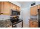 Modern kitchen with granite countertops, wooden cabinets, and stainless steel appliances at 3041 Teal Ave, Sarasota, FL 34232