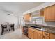 A bright kitchen with wood cabinets, a granite countertop, tiled floors, and stainless steel appliances at 3041 Teal Ave, Sarasota, FL 34232