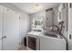 Convenient laundry room with a washer, dryer, storage cabinet, and natural light at 3041 Teal Ave, Sarasota, FL 34232