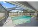 Backyard pool surrounded by a screened enclosure and concrete decking at 3041 Teal Ave, Sarasota, FL 34232