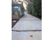 Long concrete driveway leading to a detached garage, next to a house with trees nearby at 3312 Bay Shore Rd, Sarasota, FL 34234
