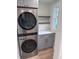 Convenient laundry area with stacked washer and dryer, shelving, and storage space at 3312 Bay Shore Rd, Sarasota, FL 34234