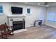 Cozy living room with a brick fireplace, hardwood floors, and large windows at 3312 Bay Shore Rd, Sarasota, FL 34234