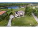 Aerial view of a large estate home with lush landscaping, long driveway and private pond at 3607 Twin Rivers Trl, Parrish, FL 34219
