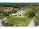 Stunning aerial view of a beautiful home with a lush green lawn and serene lake in a peaceful neighborhood at 3607 Twin Rivers Trl, Parrish, FL 34219
