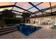 Covered pool and spa adjacent to the patio offers a view into the home under the sunset sky at 3607 Twin Rivers Trl, Parrish, FL 34219