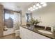 Bathroom features a large mirror, double sink vanity with granite counters, tile flooring, and tub with shower at 3607 Twin Rivers Trl, Parrish, FL 34219
