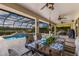 Covered patio featuring a dining table, ceiling fans, and a view of the screened-in pool area at 3607 Twin Rivers Trl, Parrish, FL 34219