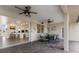 Covered outdoor patio area featuring ceiling fans, a dining table, and a seamless transition to the indoor kitchen at 3607 Twin Rivers Trl, Parrish, FL 34219