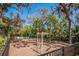 Well-maintained playground featuring climbing bars and swings, surrounded by lush landscaping and fencing at 3607 Twin Rivers Trl, Parrish, FL 34219