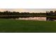 Picturesque view of a pond with reflections of the sunset sky, framed by lush greenery at 3607 Twin Rivers Trl, Parrish, FL 34219
