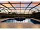 Screened-in pool and spa with brick patio offers a relaxing outdoor living space at sunset at 3607 Twin Rivers Trl, Parrish, FL 34219