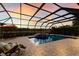 Covered pool and spa featuring a bar area under the warm light of sunset, perfect for outdoor entertaining at 3607 Twin Rivers Trl, Parrish, FL 34219