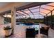 Inviting screened-in pool and spa area with brick patio, set against a tranquil outdoor backdrop at sunset at 3607 Twin Rivers Trl, Parrish, FL 34219