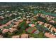 Aerial view of neighborhood showing houses surrounded by lakes and trees at 3890 Wilshire Cir # 27, Sarasota, FL 34238