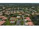 Aerial shot of community with serene lakes, tennis courts, community pool, and lush landscaping at 3890 Wilshire Cir # 27, Sarasota, FL 34238