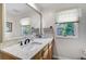Bright bathroom with wood cabinets, granite vanity, and natural light at 3890 Wilshire Cir # 27, Sarasota, FL 34238