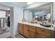 Cozy bathroom featuring a granite vanity with wood cabinets, and a large mirror at 3890 Wilshire Cir # 27, Sarasota, FL 34238