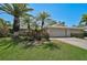 Charming house with mature landscaping, a paved driveway, and an attached two-car garage on a sunny day at 3890 Wilshire Cir # 27, Sarasota, FL 34238