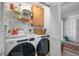 Efficient laundry room with modern washer and dryer units and ample shelving for storage and organization at 3890 Wilshire Cir # 27, Sarasota, FL 34238