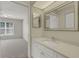 Bathroom with vanity, mirror and walk-in shower adjacent to a carpeted bedroom at 3950 Ironwood Cir # 206, Bradenton, FL 34209