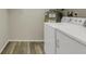 Well-lit laundry area with hardwood style floors, utility shelving, and white washer dryer at 3950 Ironwood Cir # 206, Bradenton, FL 34209
