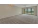 Spacious living room with neutral carpeting and sliding glass doors offering an abundance of natural light at 3950 Ironwood Cir # 206, Bradenton, FL 34209