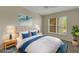 Staged bedroom with accent rug, upholstered headboard, side tables, and ocean-themed art at 3950 Ironwood Cir # 206, Bradenton, FL 34209